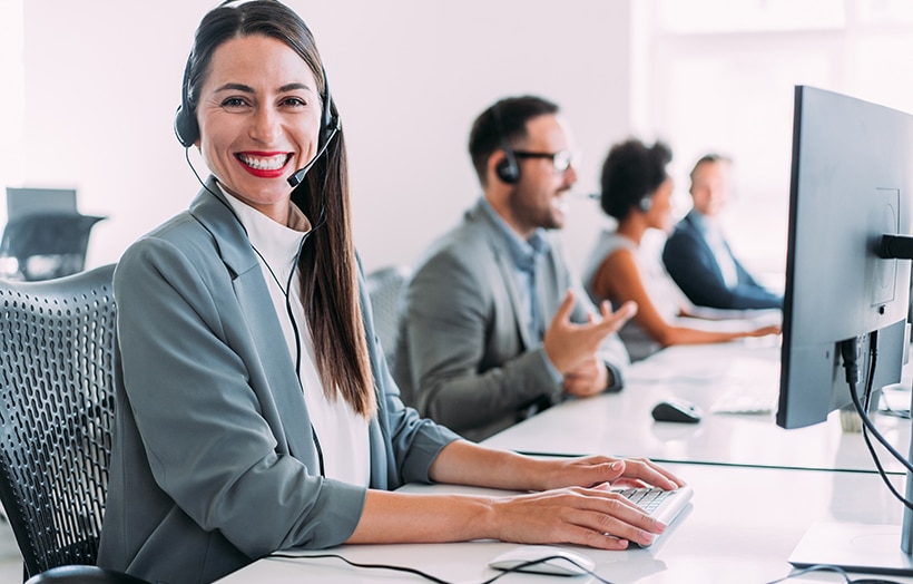 Cheerful businesswoman using a laptop in a modern office