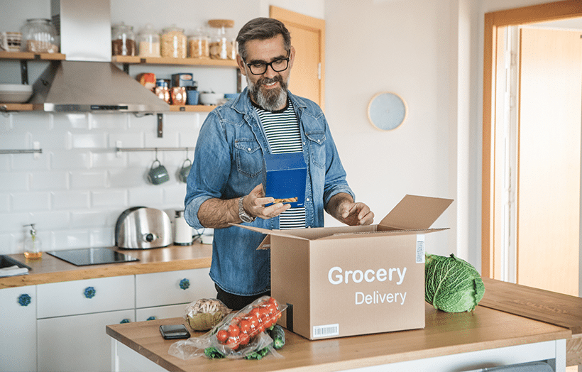 Customer receiving grocery delivery box showcasing ecommerce fulfillment and order management services