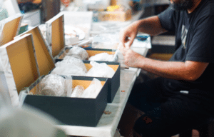 Kitting services worker packaging multi-component product bundles for order fulfillment