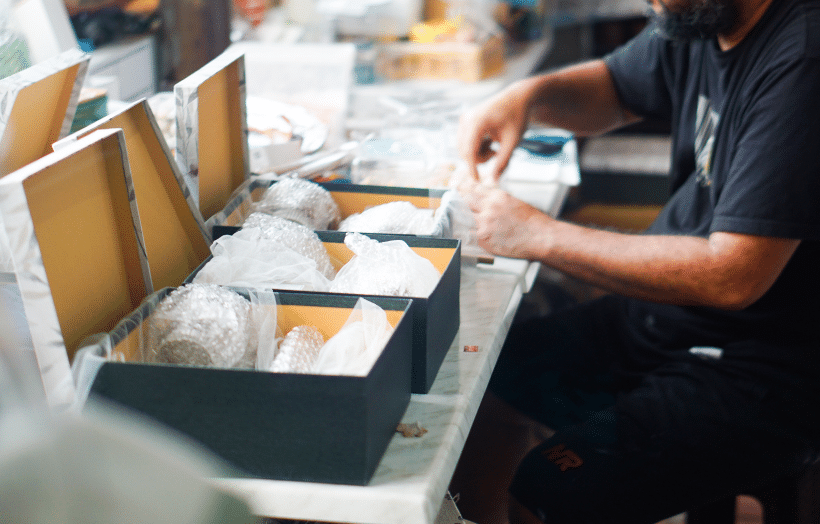 Kitting services worker packaging multi-component product bundles for order fulfillment