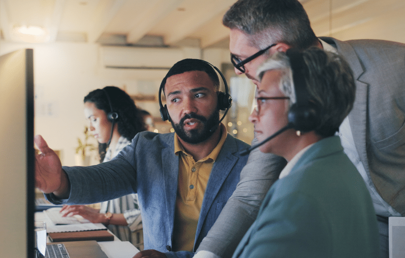 Contact center manager and associates collaborating at a workstation during an active customer interaction