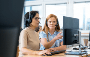 Contact center supervisor coaching customer service associate on retention strategies and call handling techniques