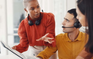 Sales team reviewing performance data and discussing strategy at a computer.
