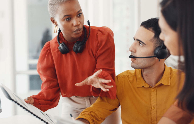 Sales team reviewing performance data and discussing strategy at a computer.