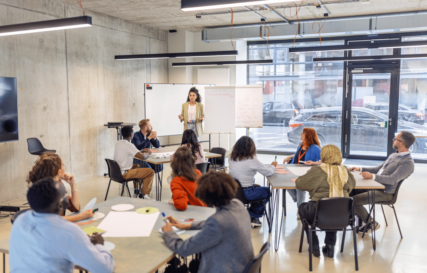 Facilitator leads a corporate training session with employees working in small groups