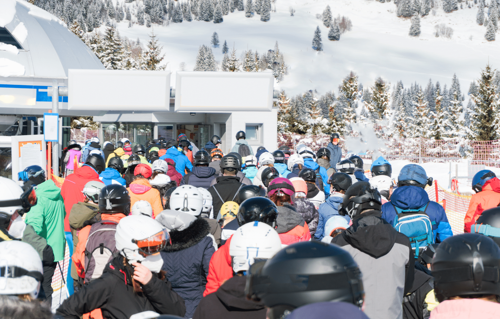 Crowd of skiers packed together waiting to board a chairlift at a busy mountain resort